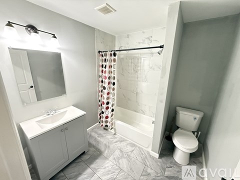 A white bathroom with a sink, toilet, and shower.