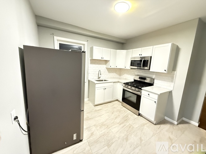 A kitchen with white cabinets and appliances is available for rent.