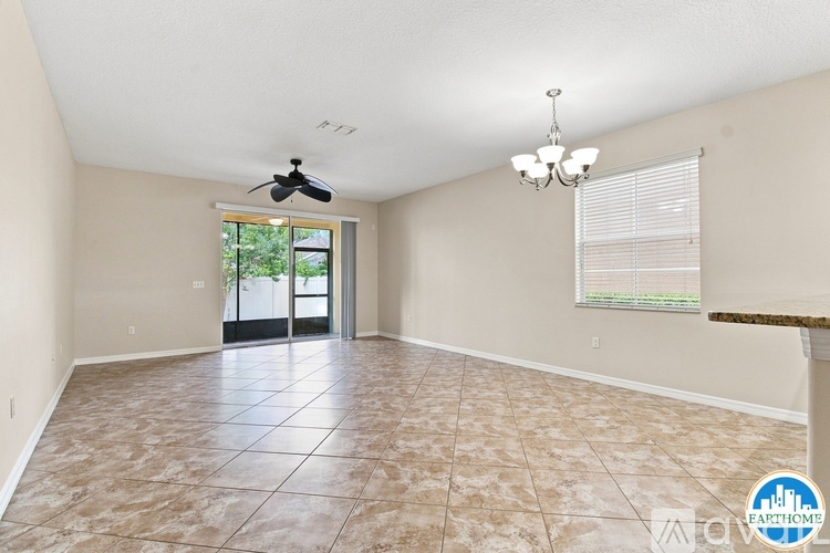 A spacious room with tiled flooring and a ceiling fan.