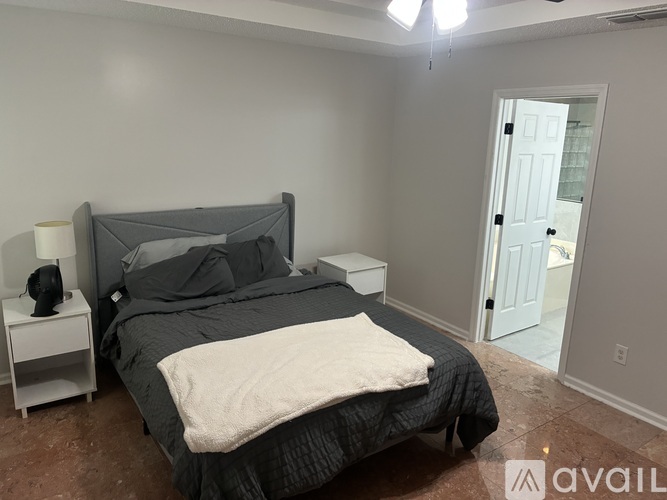 A bedroom with a bed, nightstand, and lamp.