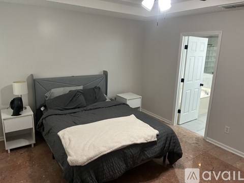 A bedroom with a bed, nightstand, and lamp.