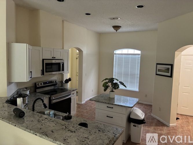 A kitchen with granite countertops and a microwave above the stove.