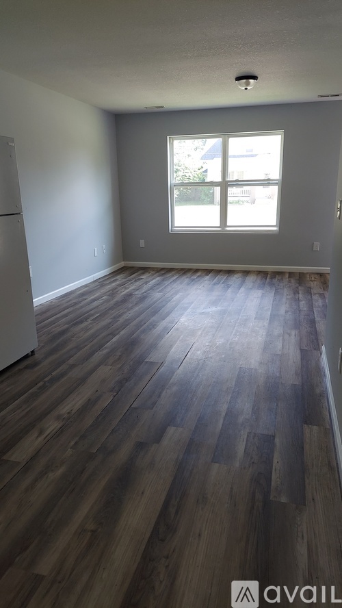 A room with wooden flooring and a window.