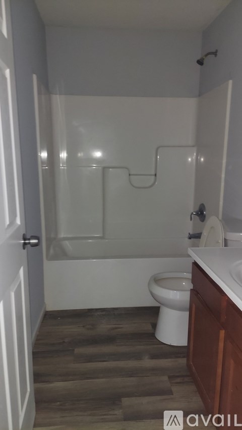 A bathroom with a toilet, sink and shower.