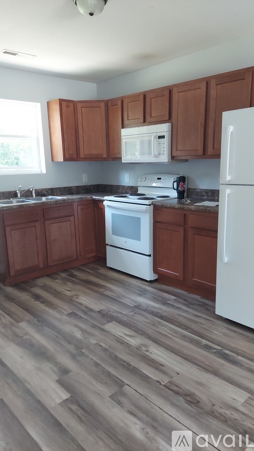 A kitchen with wooden cabinets and a white fridge.