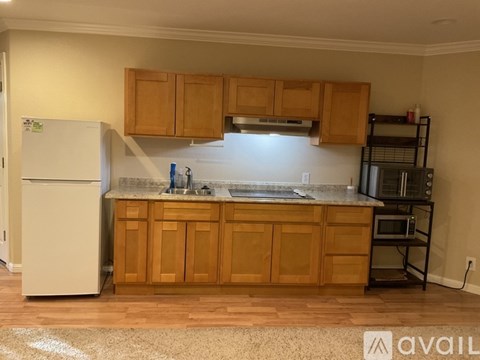 A kitchen with wooden cabinets and a white fridge.