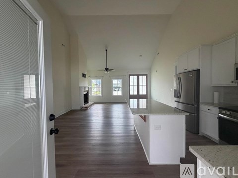 A kitchen with white cabinets and a refrigerator in a house.