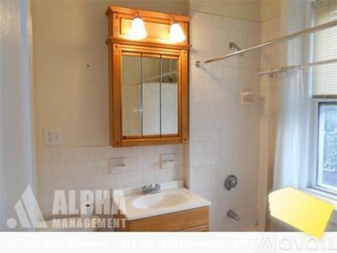 A bathroom with a sink, mirror, and shower.