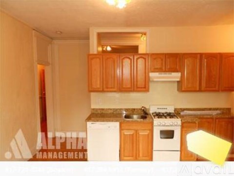 A kitchen with wooden cabinets and a white stove top oven.