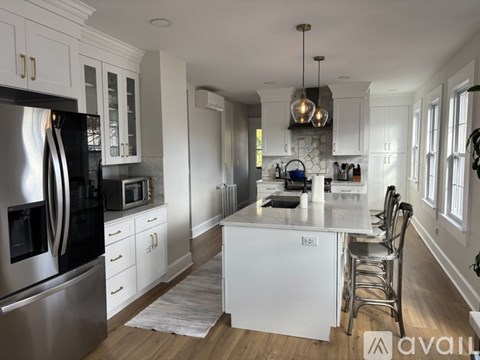 A modern kitchen with a large island and stainless steel appliances.