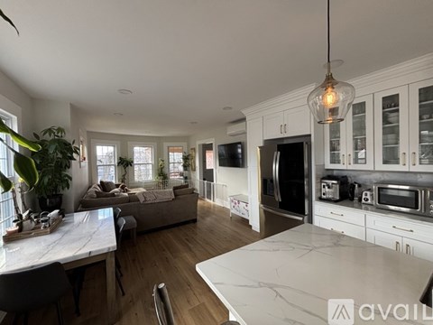 A kitchen with a marble countertop and a dining table with chairs.