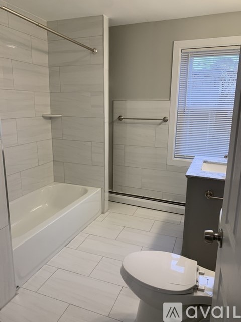 A white toilet with a white bathtub in a bathroom.