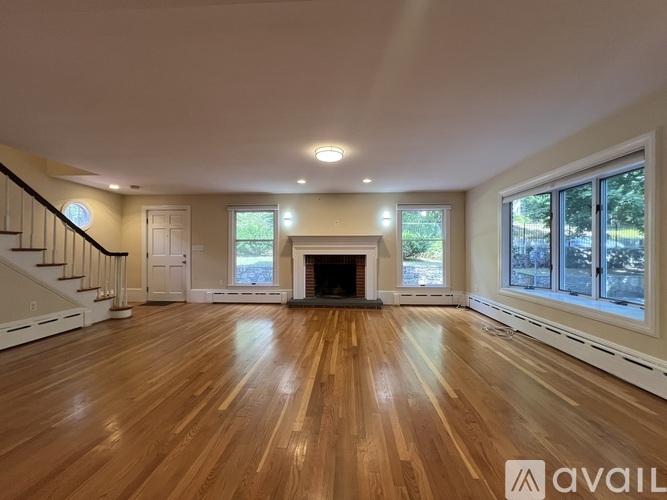 A spacious living room with hardwood floors and a fireplace.