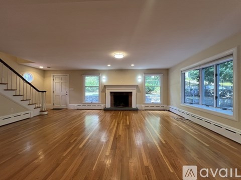 A spacious living room with hardwood floors and a fireplace.