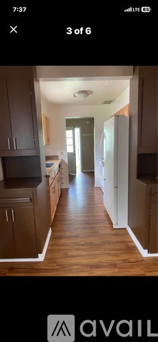 A kitchen with wooden cabinets and a refrigerator.
