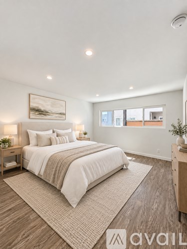 A bedroom with a large bed and a painting on the wall.