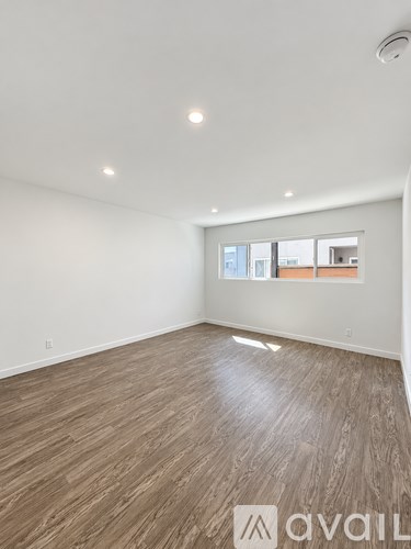 A room with wooden flooring and a window.