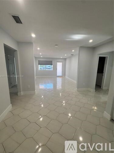 A spacious room with a tiled floor and a window letting in natural light.