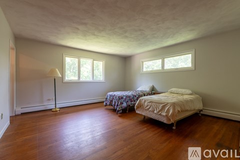 A bedroom with a bed, a lamp, and a window.