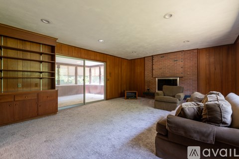 A living room with a grey couch and a fireplace.