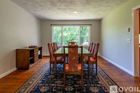 A dining room with a table and chairs.