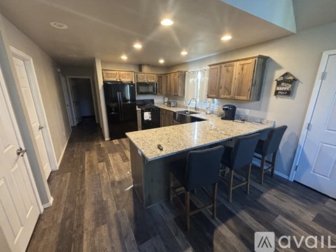 A kitchen with a granite countertop and wooden cabinets.