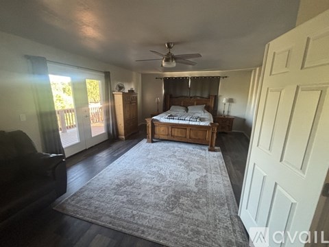 A bedroom with a bed, dresser, and couch.