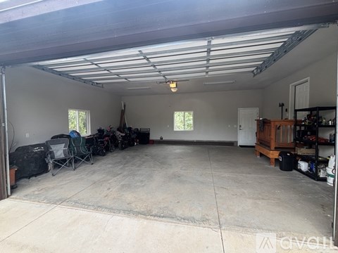 A spacious garage with a concrete floor and a ceiling covered with metal beams.