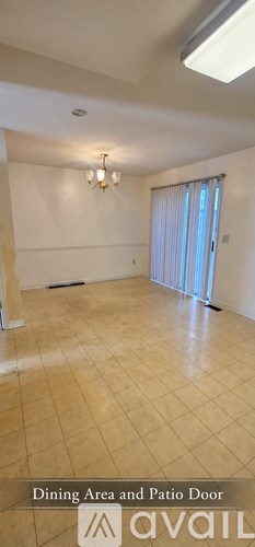 A spacious room with a dining area and patio door.