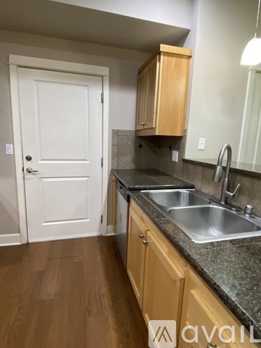 A kitchen with a white door and wooden cabinets.