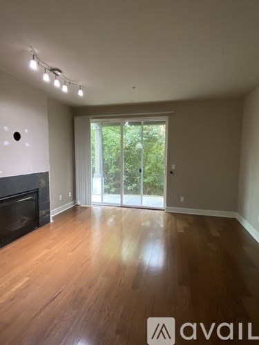 A room with a fireplace and sliding glass doors leading to a garden.