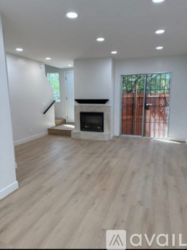 A spacious living room with a fireplace and wooden flooring.