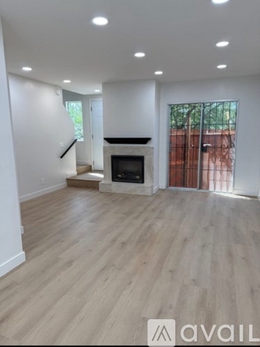A spacious living room with a fireplace and wooden flooring.