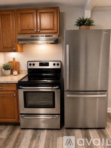 A modern kitchen with a stainless steel refrigerator and oven.