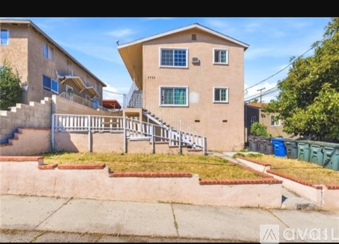 A two-story house with a staircase leading to the front door.