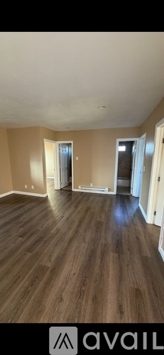A room with wooden flooring and a white ceiling.