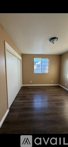 A room with wooden flooring and a window.