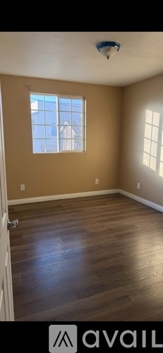 A room with wooden flooring and a window.