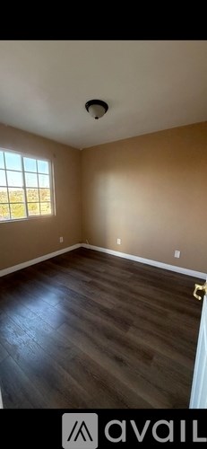 A room with wooden flooring and a window.