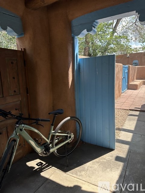 A bicycle is parked in a sunny alcove.