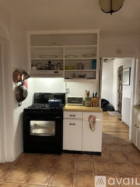 A kitchen with a black stove top oven and white cabinets.
