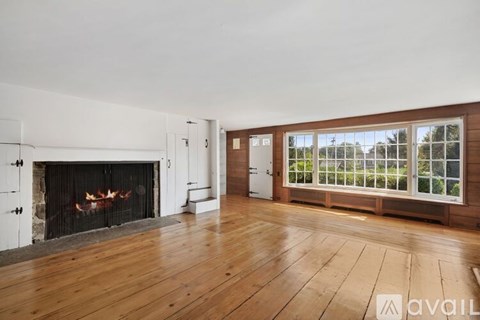 A room with a fireplace and wooden floors.