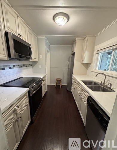 A kitchen with white cabinets and a black stove top oven.