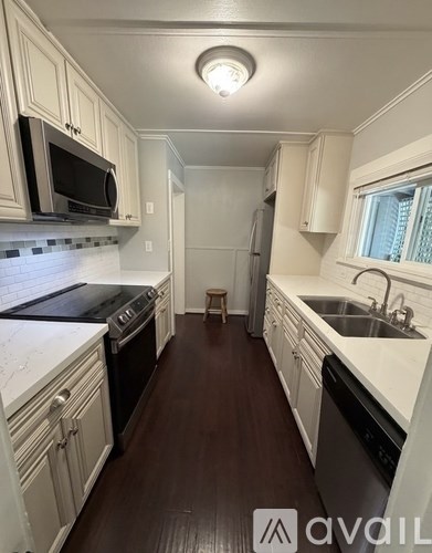 A kitchen with white cabinets and a black stove top oven.