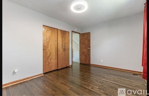 A room with wooden floors and a white ceiling with a light fixture.