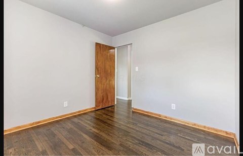 A room with a wooden floor and a wooden door.
