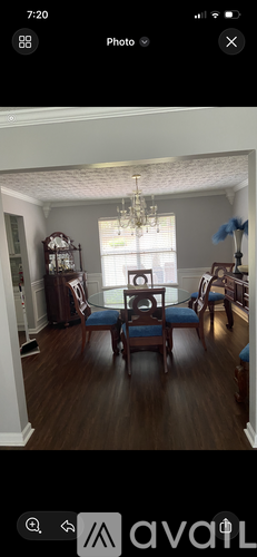 A room with a wooden floor and a chandelier hanging from the ceiling.