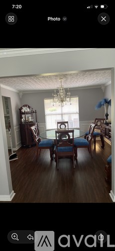 A room with a wooden floor and a chandelier hanging from the ceiling.