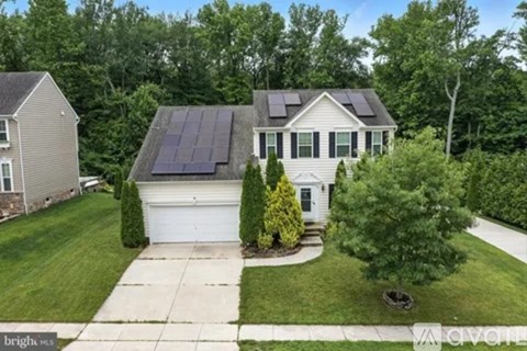 A house with a solar panel on the roof is for sale.
