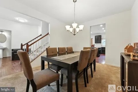 A dining room with a table and chairs.